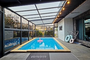 Una piscina cubierta por vidrio con vistas despejadas del entorno.