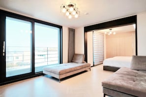 A modern bedroom with a sofa, a bed, and a large window. - dalkompoolvilla (Jeju-si)