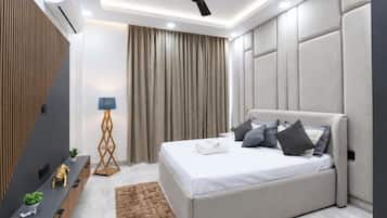 A modern bedroom with a bed, a ceiling fan, a desk, and a floor lamp.