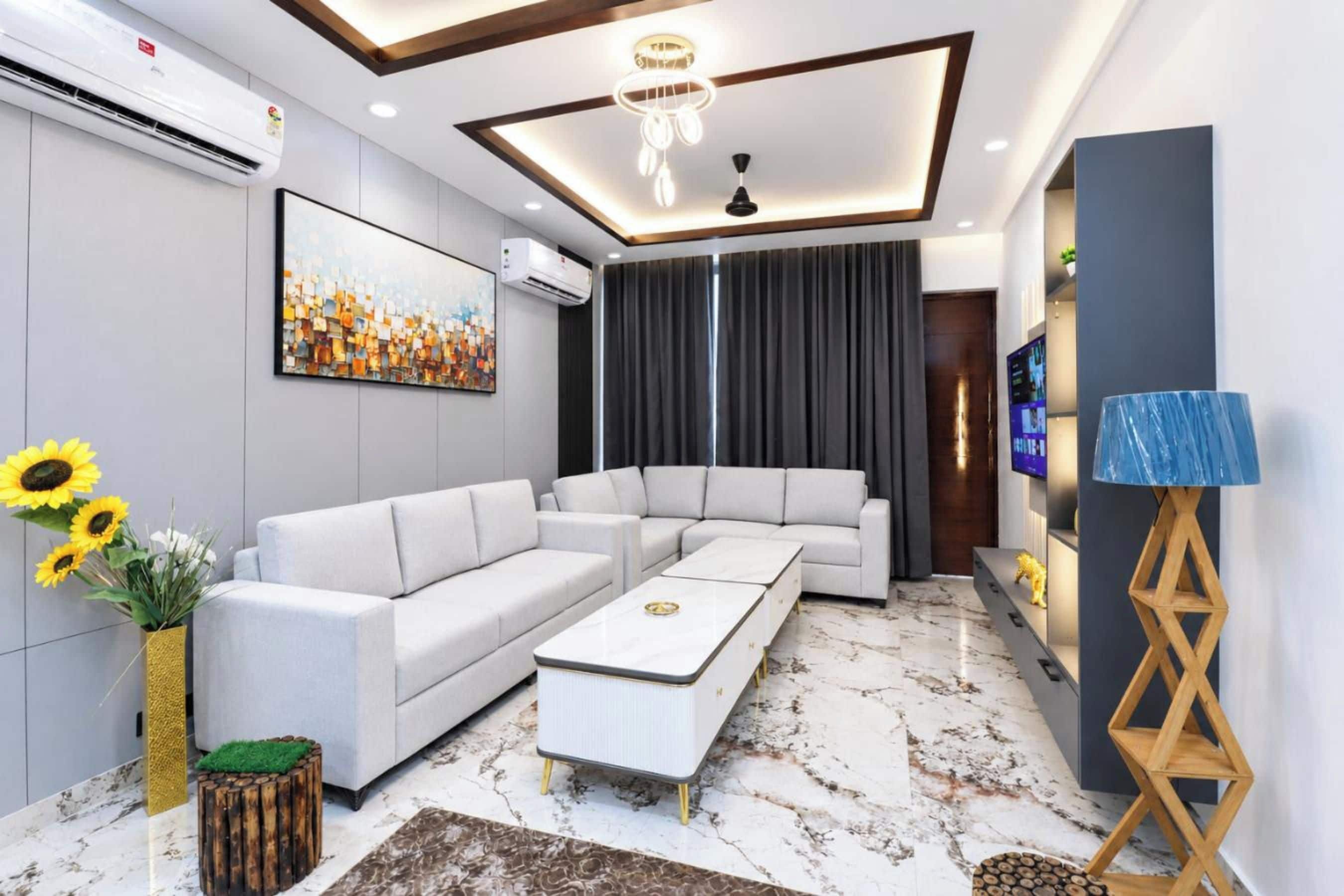 Una sala de estar moderna con un sofá modular, una mesa de centro y un televisor montado en la pared.