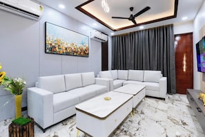 Una sala moderna con un sofá modular, una mesa de centro y un ventilador de techo.