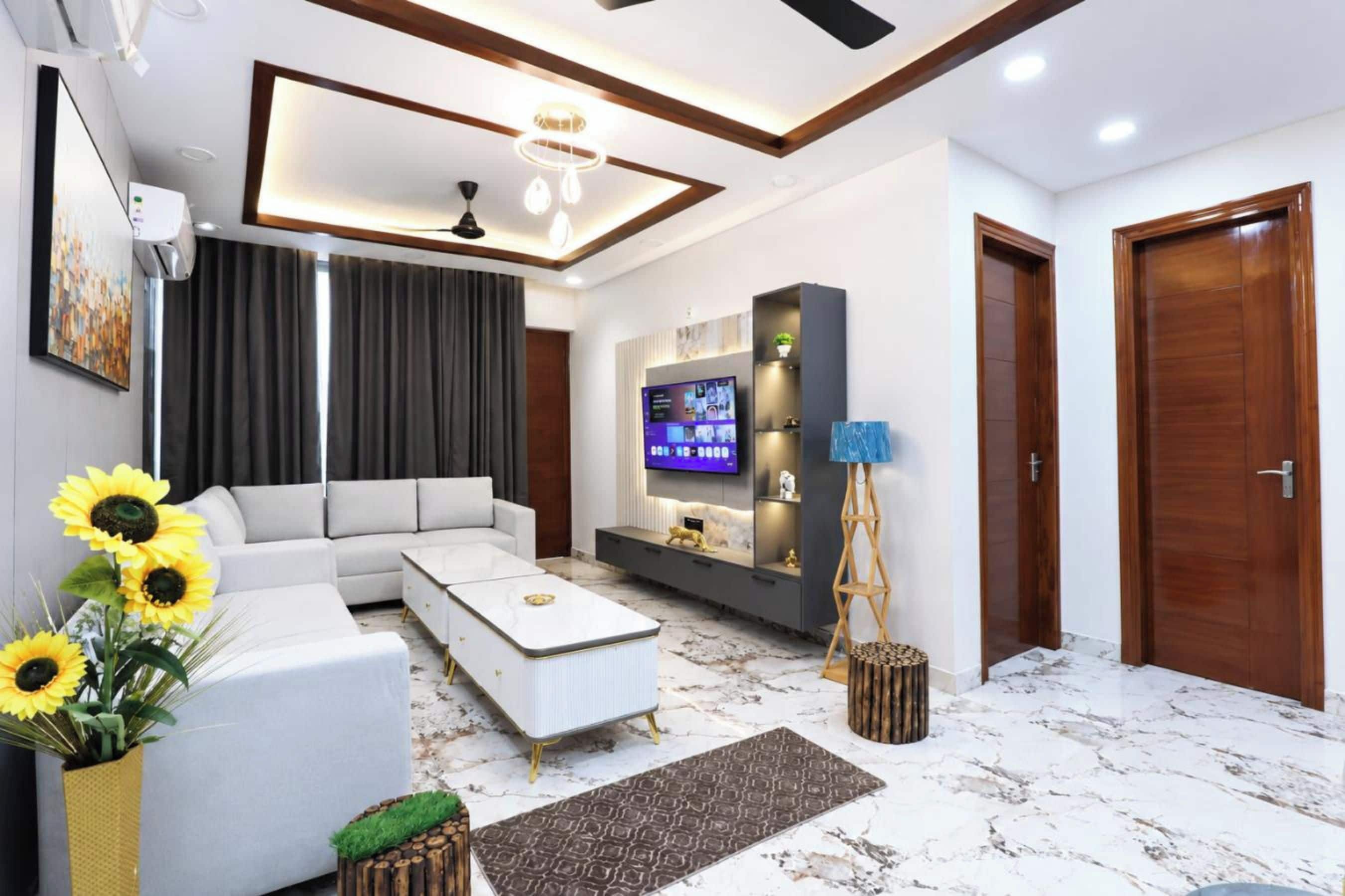 Un salon moderne avec un canapé d’angle, un téléviseur à écran plat et une lampe de sol décorative.