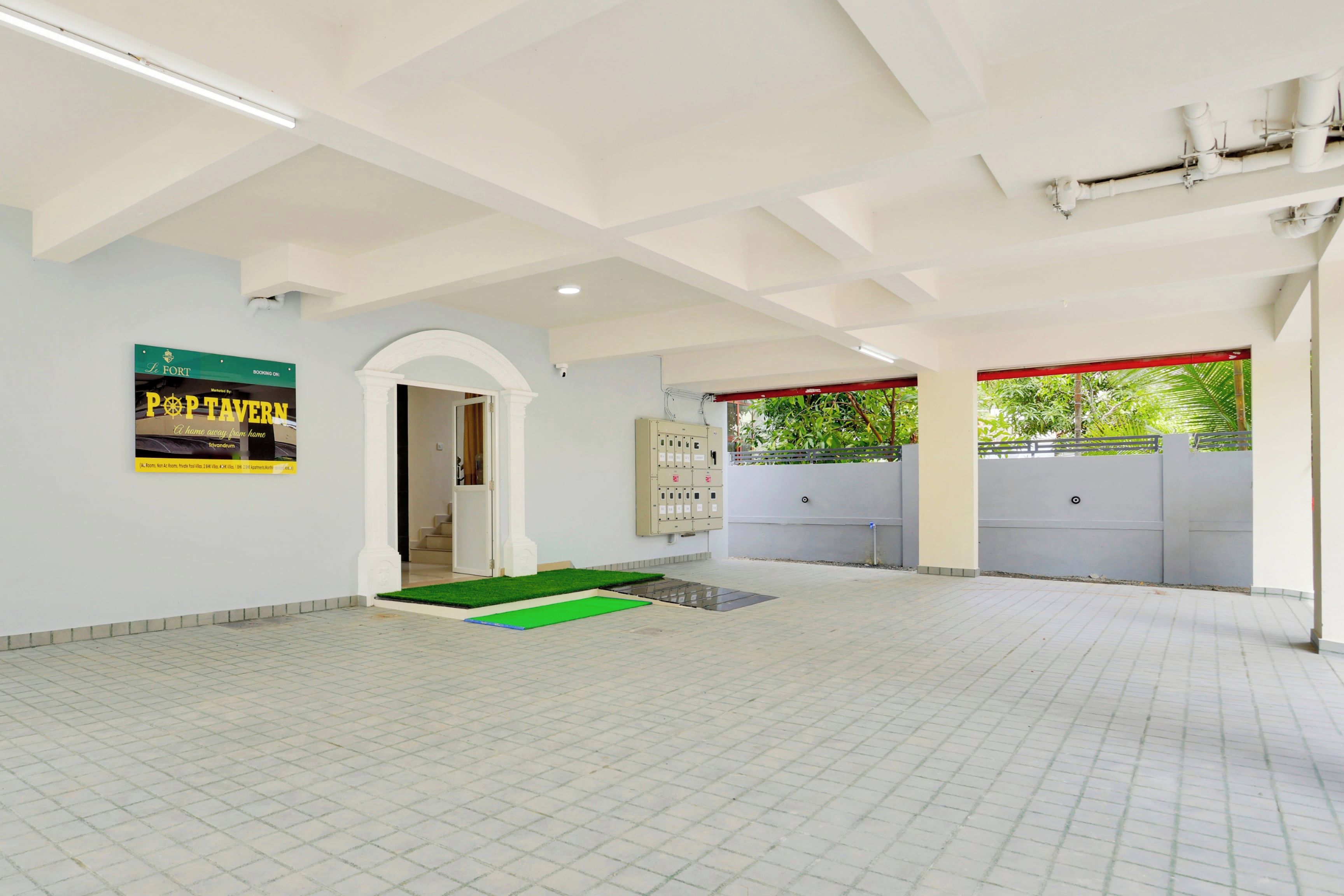 A spacious indoor area with a tiled floor, a green artificial grass entrance, and a sign advertising a home away from home experience.