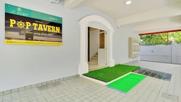 Interno di un hotel con un cartello che riporta 'POP TAVERN' e vista sull'esterno.