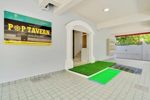 A hotel interior with a sign for 'POP TAVERN' and a view of the outside. - Super Collection O Lefort LUXE  (Trivandrum)