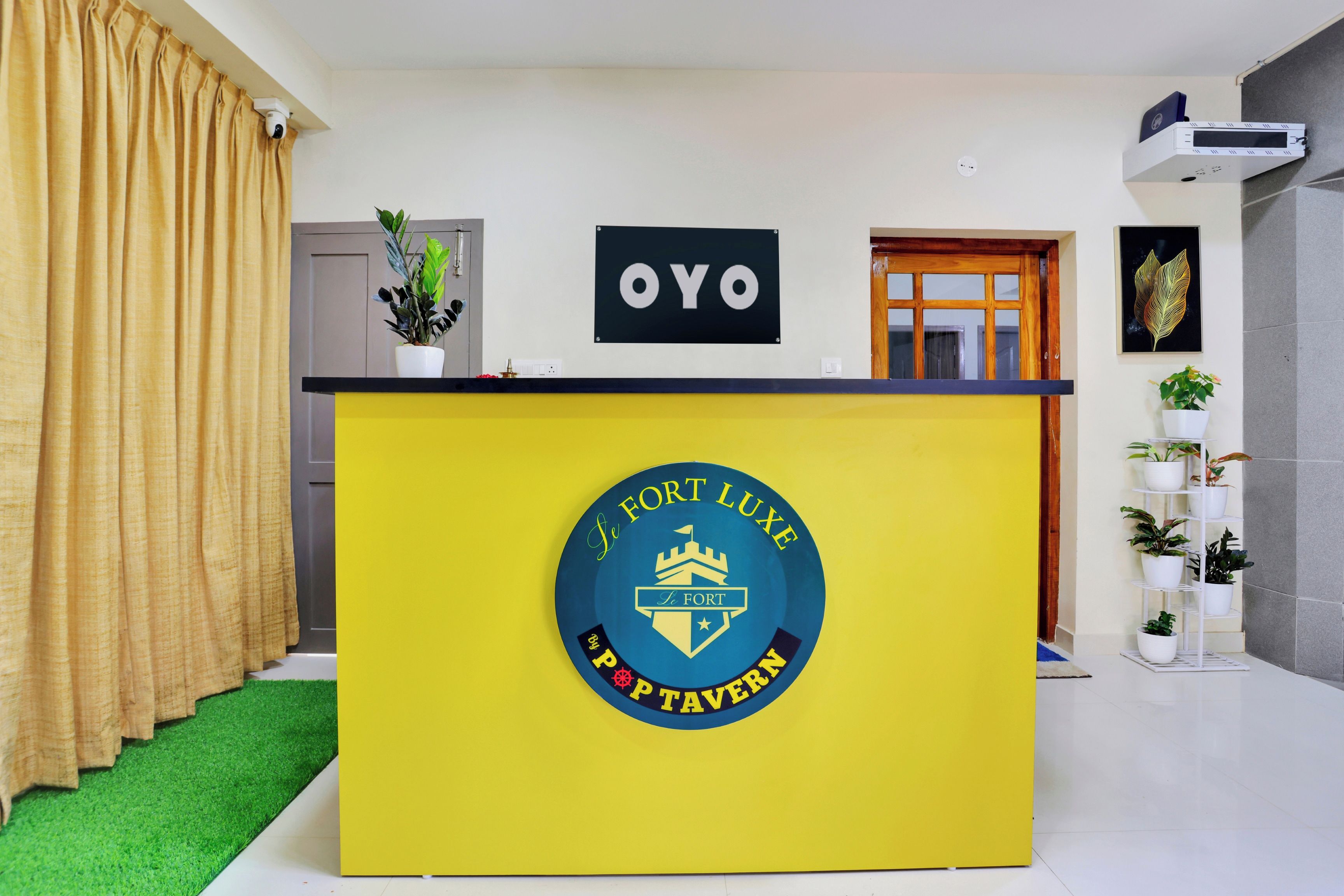 Una mesa de recepción con un letrero que dice 'OYO' y el logotipo de 'Le Fort Luxe'.