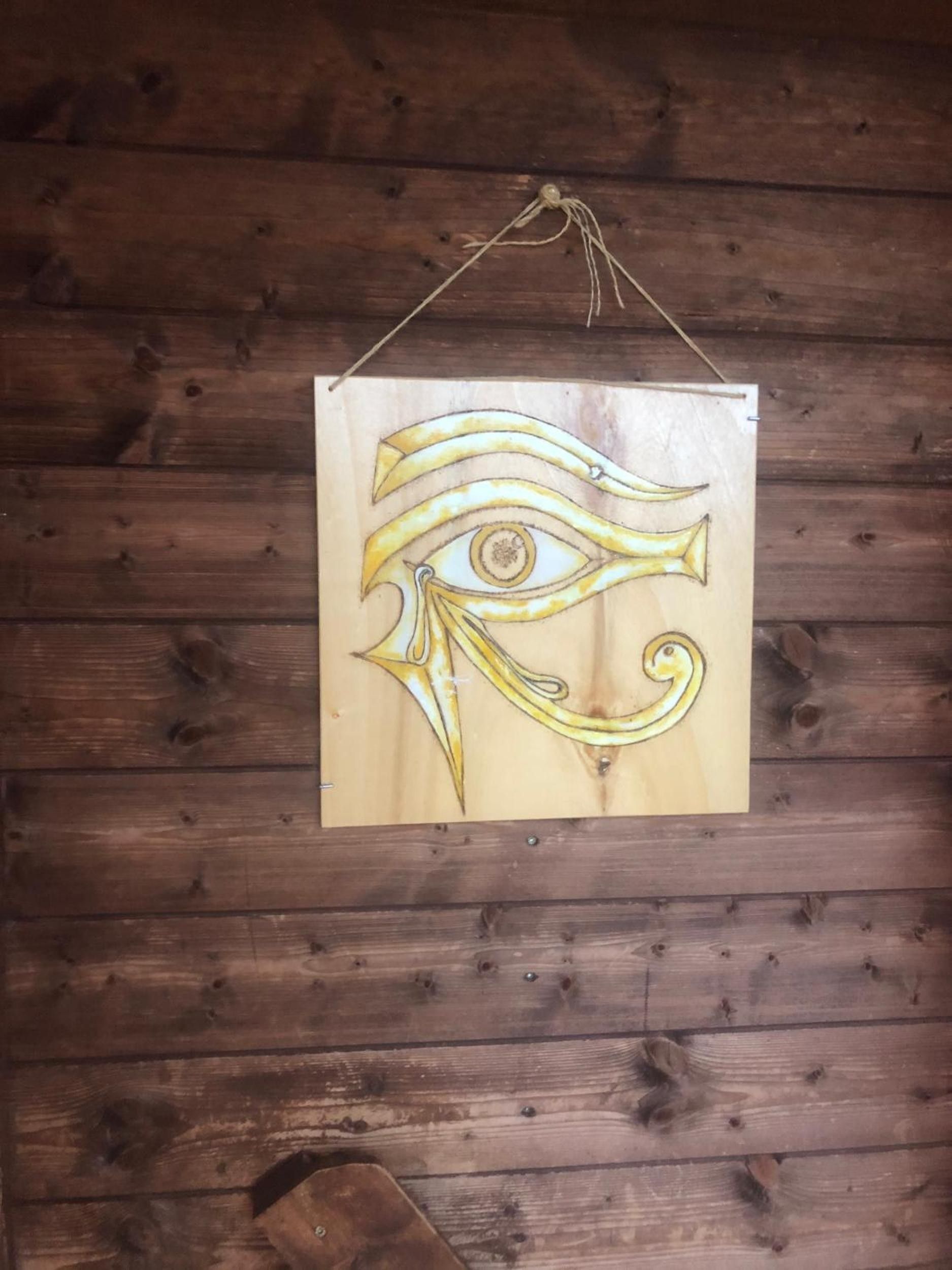 A wooden wall with a hanging object that appears to be a decorative item.