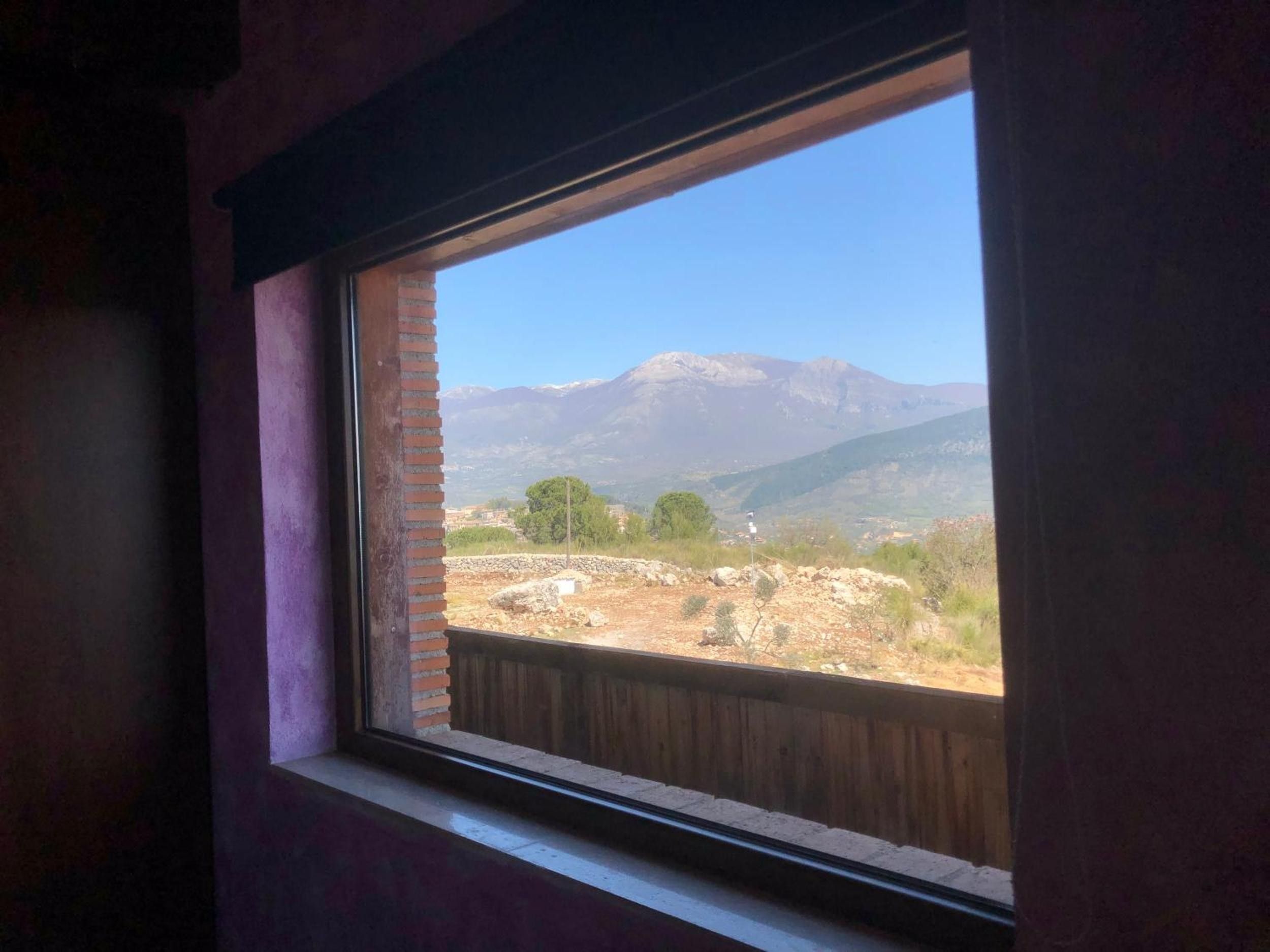 Ein Fenster mit Blick auf eine gebirgige Landschaft.