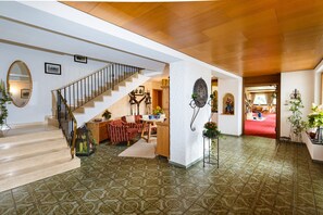 A spacious interior with a staircase, a dining area, and a hallway leading to another room. - Dahoam Holiday Apartment at Schneidersepp with a terrace, bathroom with shower and toilet, Wi-Fi, max. 3 guests (Ruhpolding)
