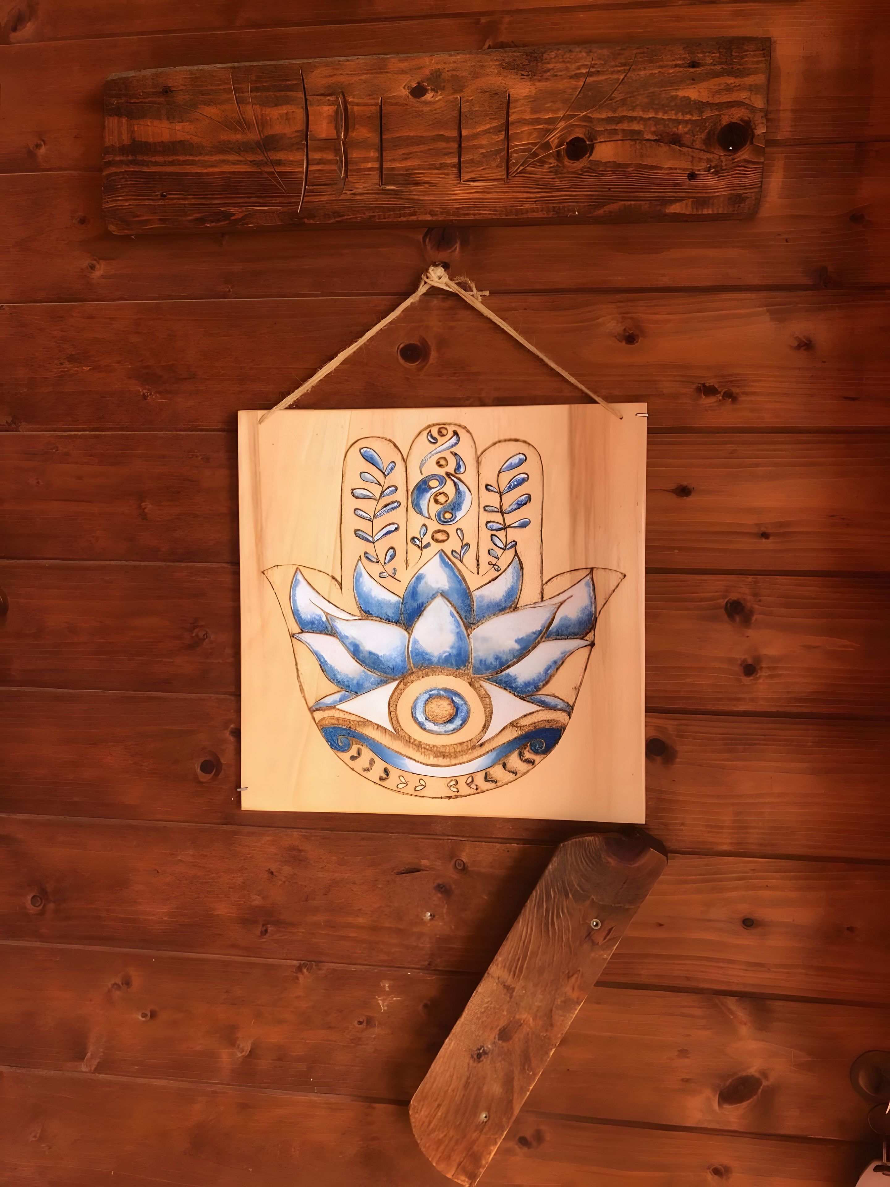 A wooden wall with a hanging object that appears to be a decorative item.