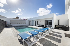 A modern outdoor pool area with lounge chairs and a small seating area. - Casa Alma by Escape Home (Tías)