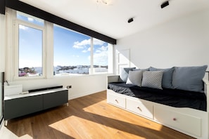 A modern bedroom with a large window, a bed with storage drawers, and a built-in bench. - Casa Alma by Escape Home (Tías)