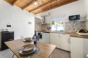 A compact kitchen with white cabinets, a wooden ceiling, and a built-in microwave. - Apartamento Alma 1 by Escape Home (Tías)