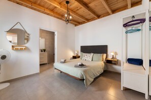 A bedroom with a bed, bedside tables, a mirror, and a hanging rack. - Apartamento Alma 2 by Escape Home (Tías)