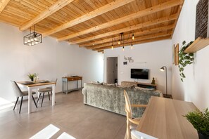 A modern interior with a wooden ceiling, a dining area, a kitchen, and a living space. - Apartamento Alma 2 by Escape Home (Tías)