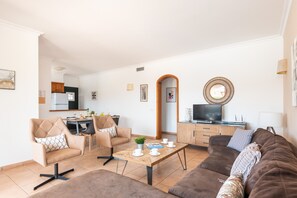 A modern living room with a sofa, chairs, a coffee table, and a TV. - Villa Conchita by Escape Home (Torre Solí Nou)