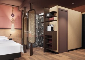 A modern bedroom with a bed, a wall-mounted TV, and built-in shelving. - Oceania Paris 17 (Paris)