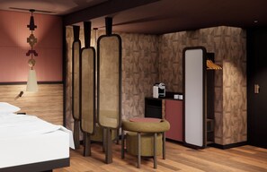 A modern bedroom with a bed, a small table, two chairs, a wardrobe, and a kitchenette. - Oceania Paris 17 (Paris)