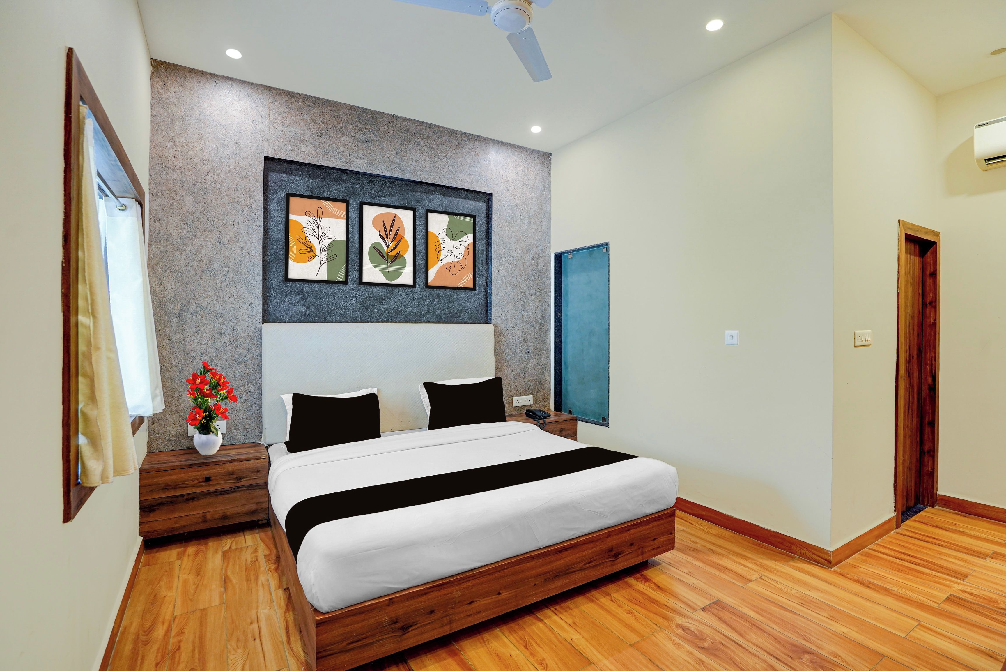 Un dormitorio moderno con cama de madera, ventilador de techo y aire acondicionado instalado en la pared.