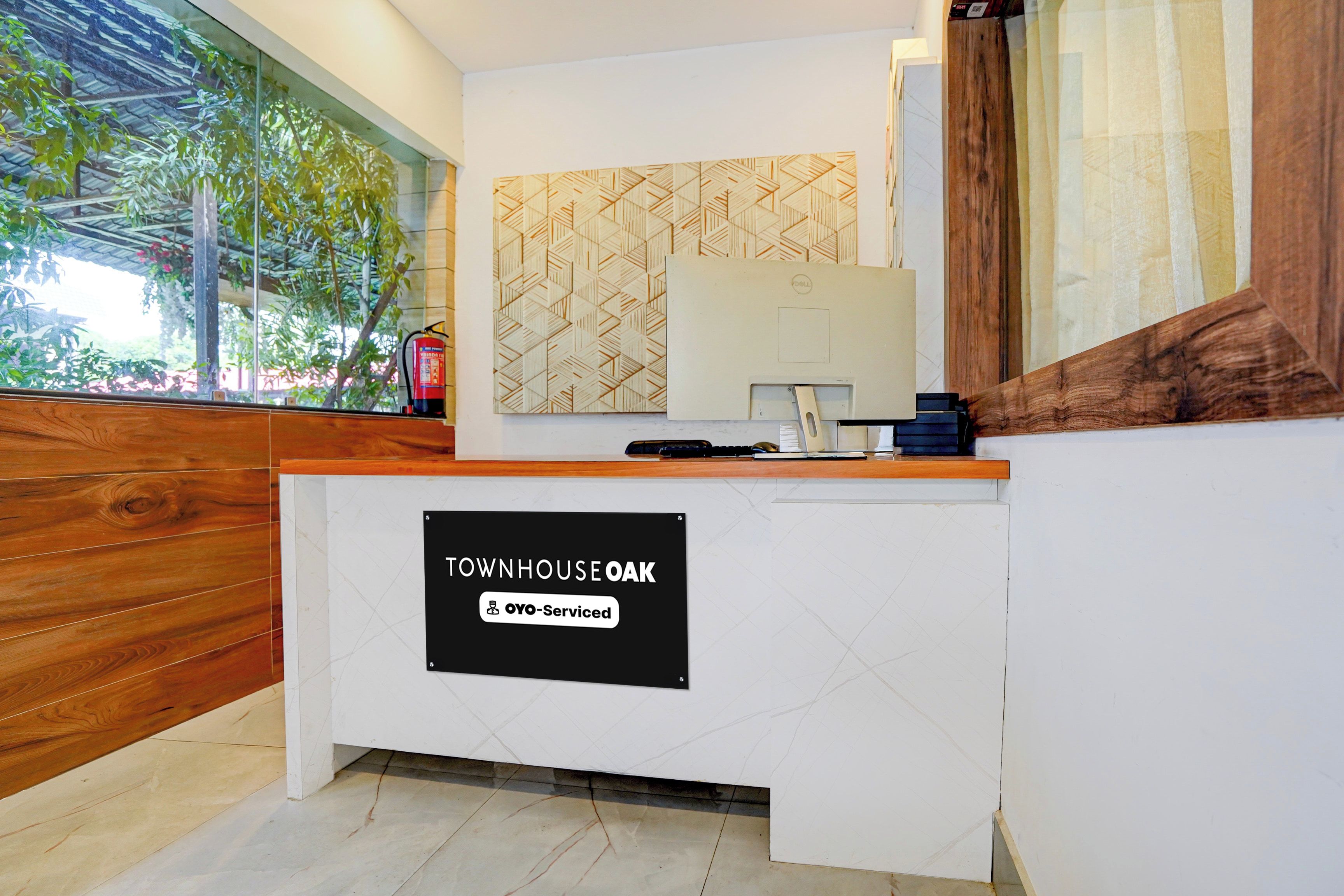 Una mesa de recepción con un letrero que dice 'TOWNHOUSE OAK' y un monitor de computadora Dell.