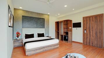 A modern bedroom with a large bed, a ceiling fan, and a wooden wardrobe.