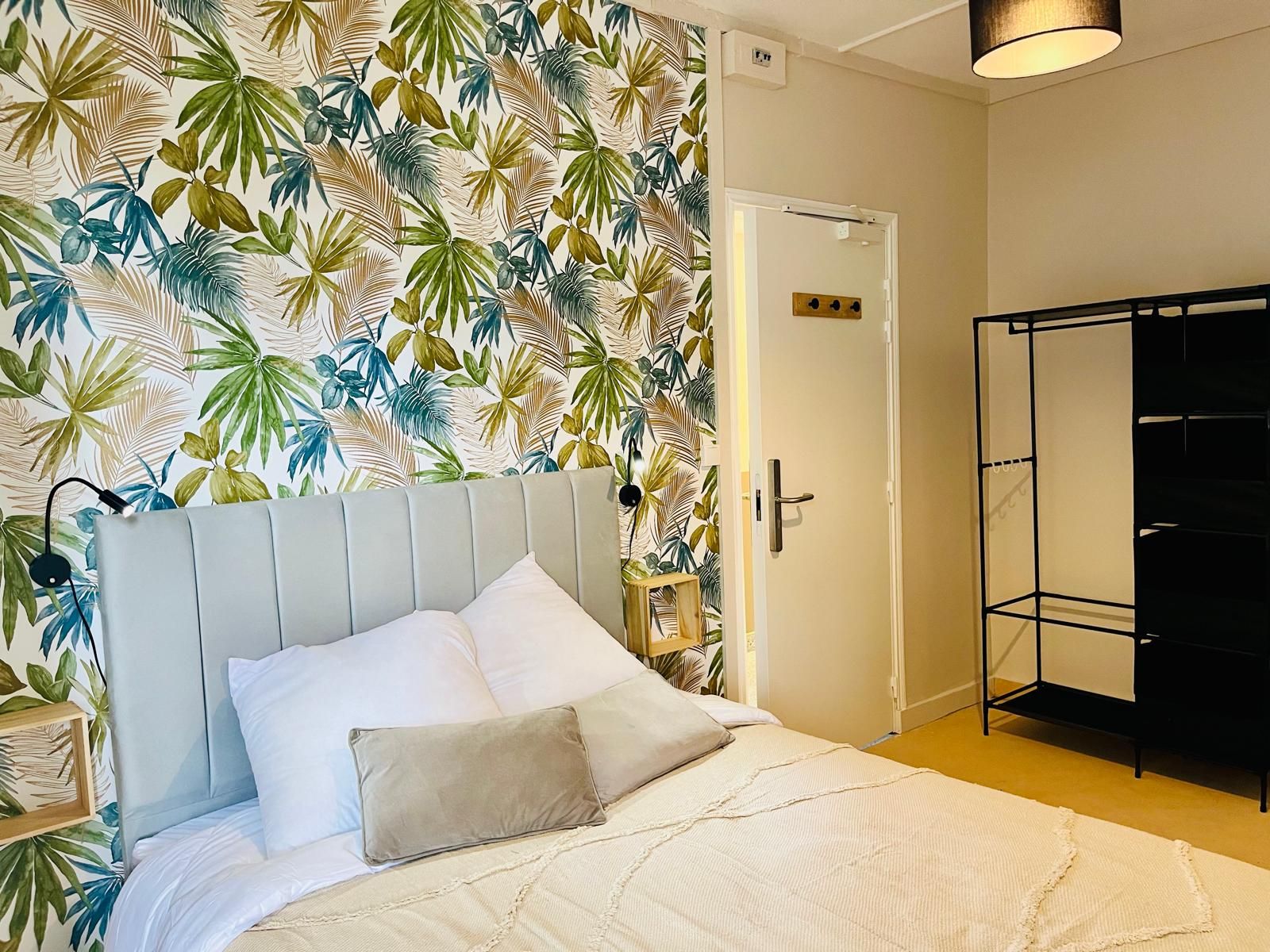 A bedroom with a bed, a wardrobe, and a door.