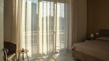 A bedroom with a bed, a nightstand, a chair, and a table.