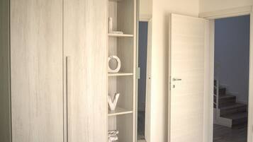 Ein Zimmer mit einem Schrank, einer Tür und einer Treppe.