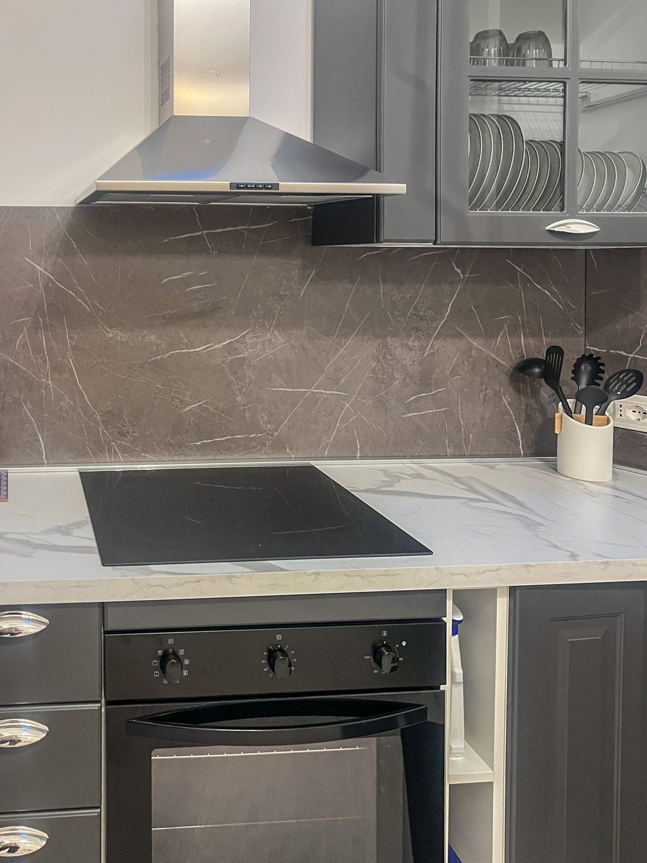A modern kitchen with a built-in oven, a stovetop, and a microwave.