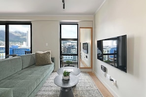 Een moderne woonkamer met een bank, salontafel en een flatscreen televisie.