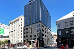 Een modern gebouw met een glazen gevel en een bord waarop 'Tokyo' staat.