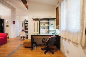 A modern office space with a desk, office chair, and a red sofa. - Borgo Dei Greci Loft (Florence)