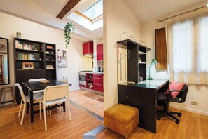 A modern apartment with a dining area, kitchen, and a workspace with a desk and chair. - Borgo Dei Greci Loft (Florence)