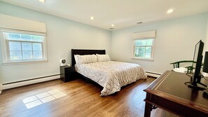 A bedroom with a bed, nightstand, and a desk with a computer. - Spacious 5-bedroom house in tranquil Princeton (Princeton)