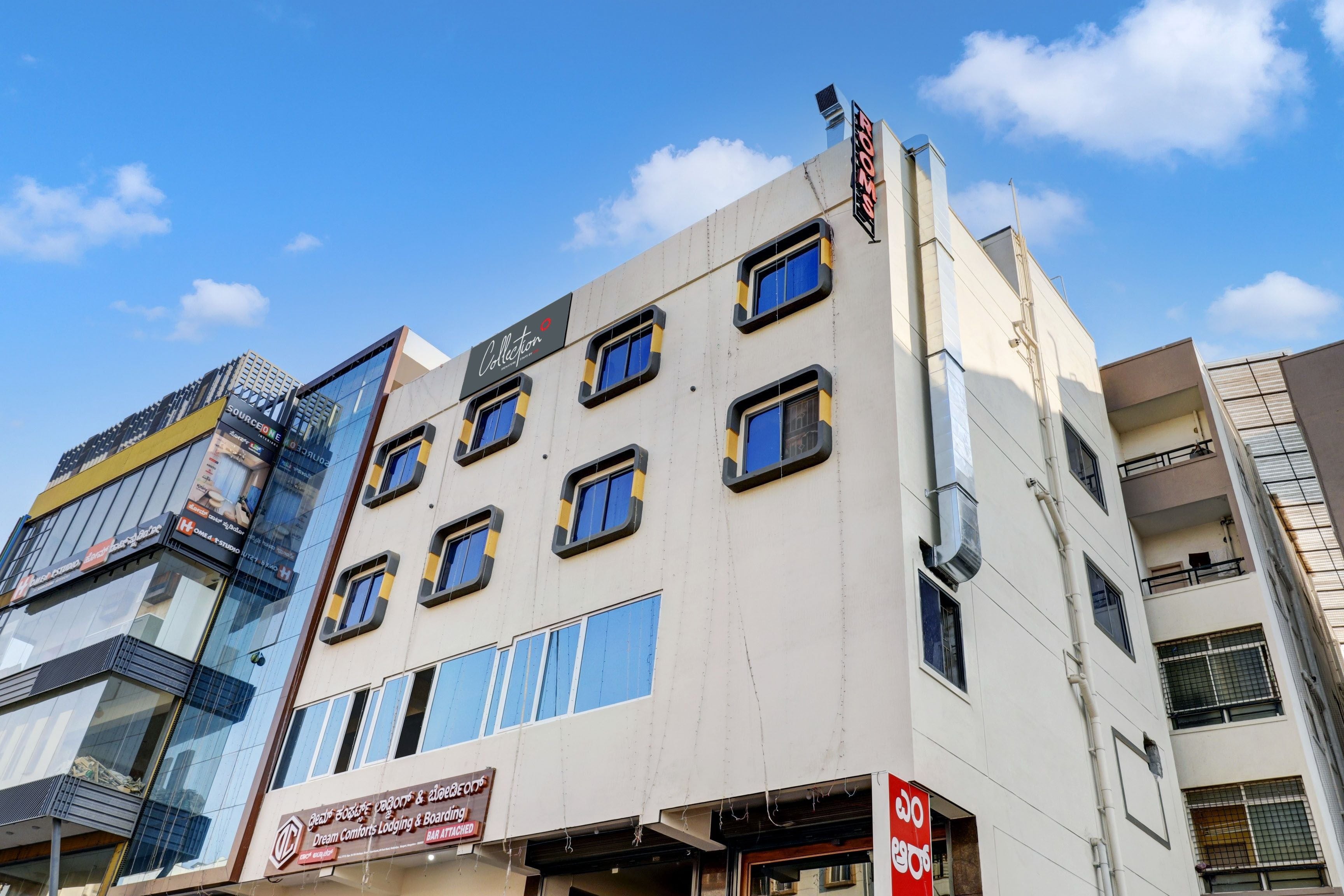 Un edificio de varios pisos con fachada moderna, que combina paneles de vidrio y superficies sólidas.