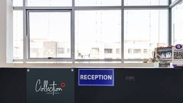 A reception area with a large window, a sign for 'Collection', and a 'Reception' sign.