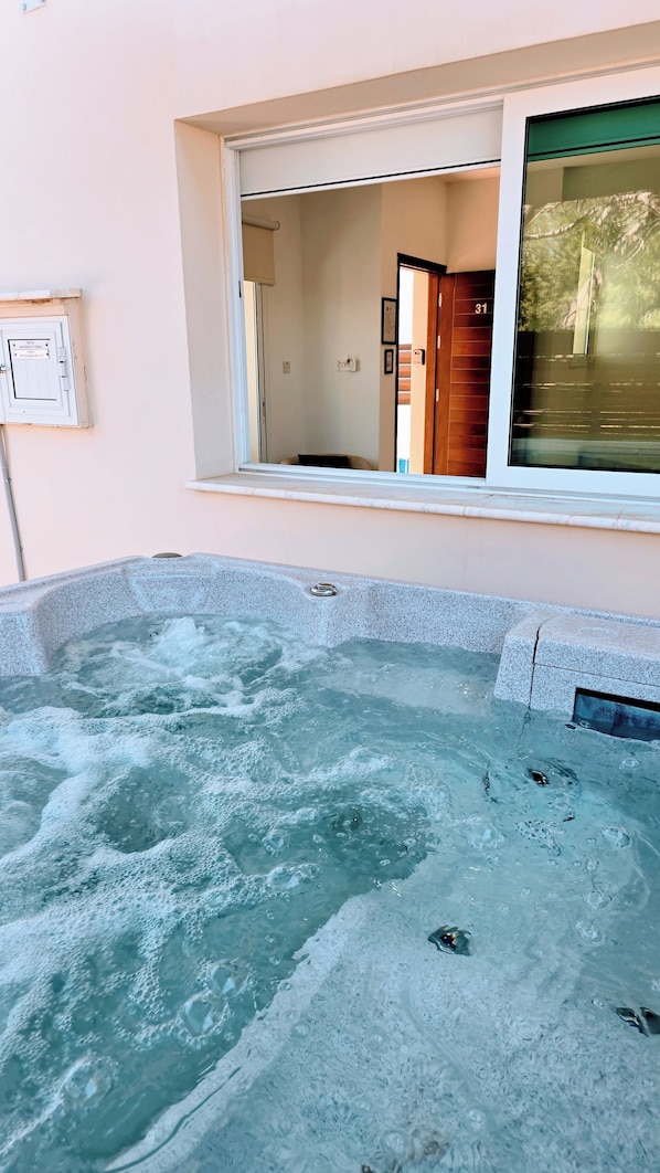 A hot tub with a view of a room through a window. - Villa Alkioni 31 with Private Pool & Jacuzzi (Paralimni)