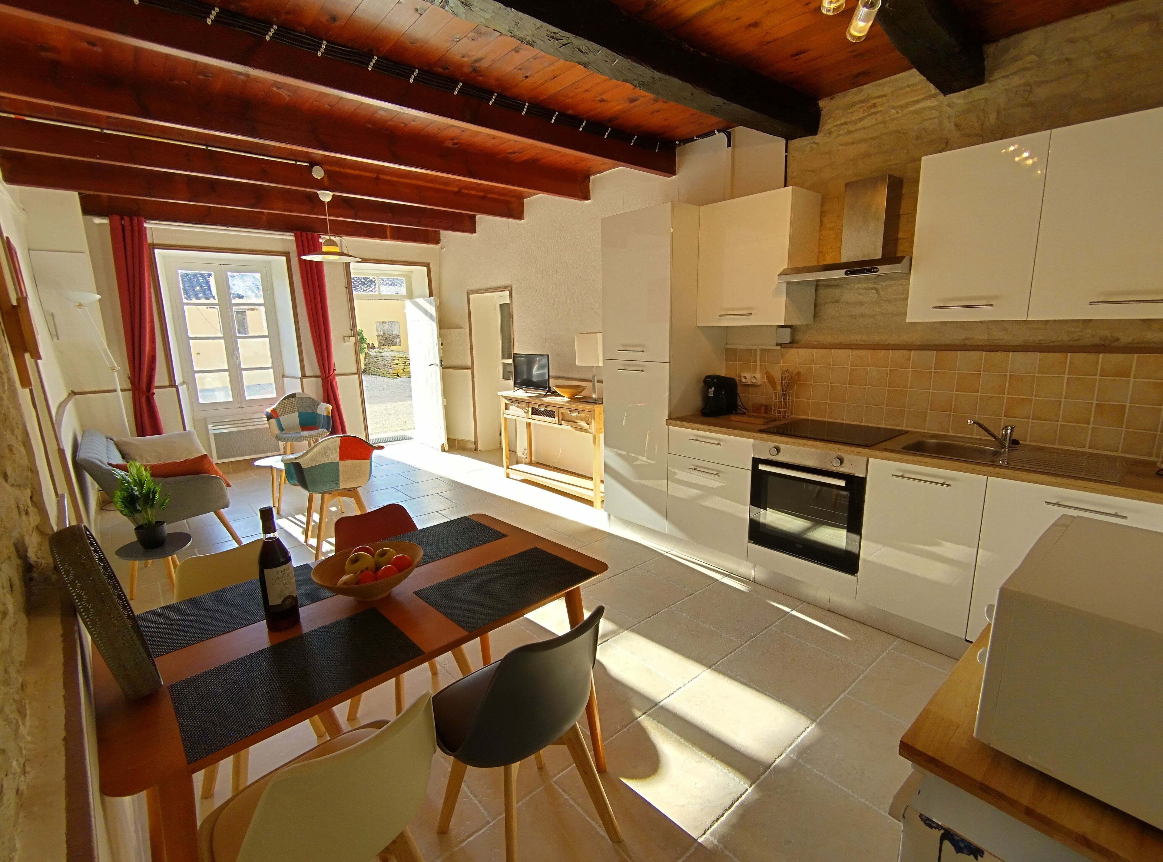 Una cucina moderna con mobili bianchi, un piano di lavoro in legno e un forno integrato.
