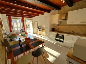 Eine moderne Küche mit weißen Schränken, einer Holz Arbeitsplatte und einem eingebauten Backofen.