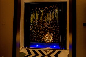 A hotel entrance with a decorative wall of flowers and a neon sign reading 'Jaiye Villa'. - Jaiye Villa Entire Place (Lekki)