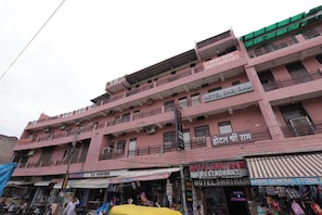 A pink multi-story building with signs for 'Hotel Shriram' and 'Laxmi General Store'. - Hotel Shri Ram (Agra)