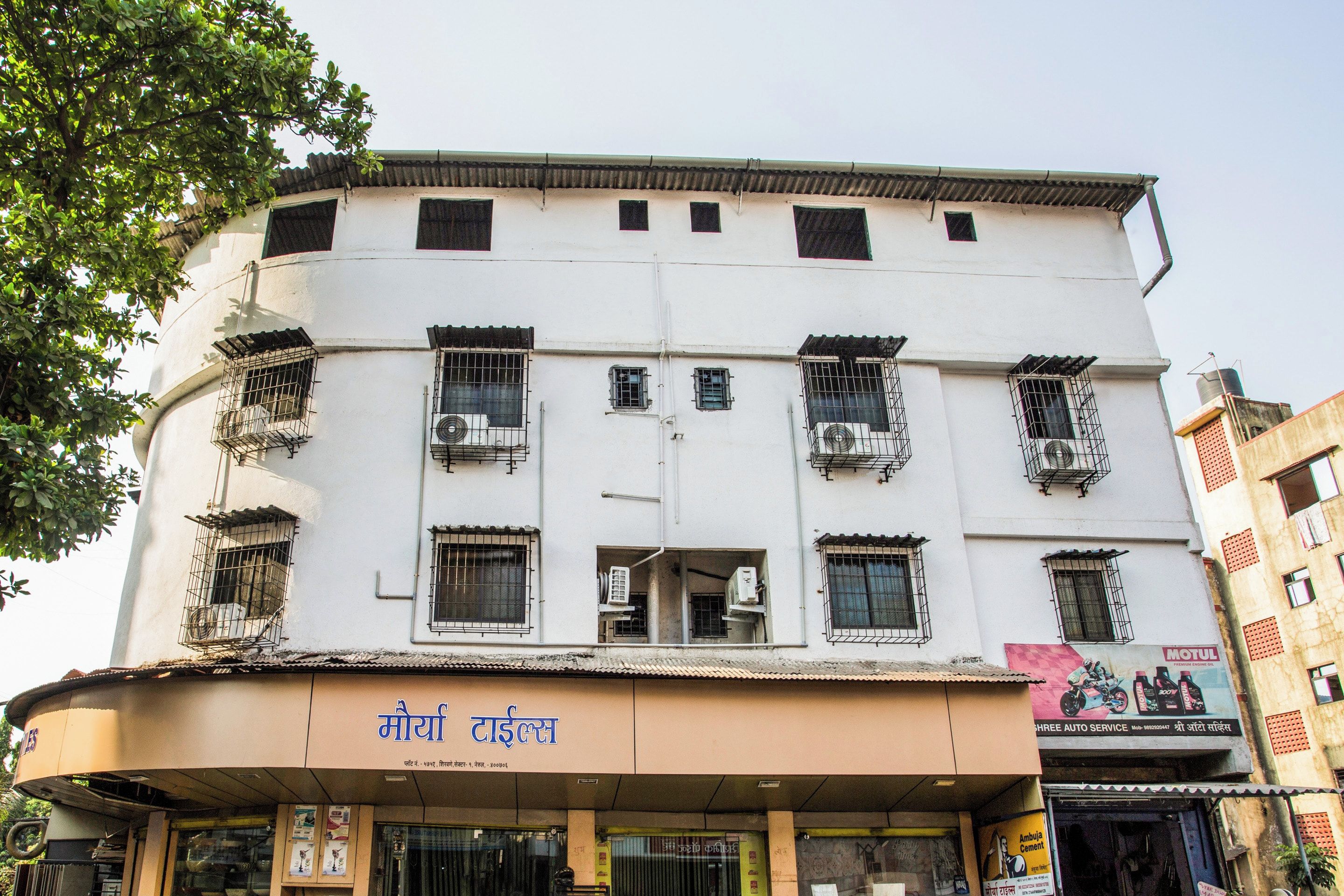 A multi-story building with multiple air conditioning units installed on the exterior.