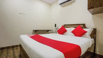 Una habitación de hotel con una cama, teléfono y equipo de aire acondicionado.
