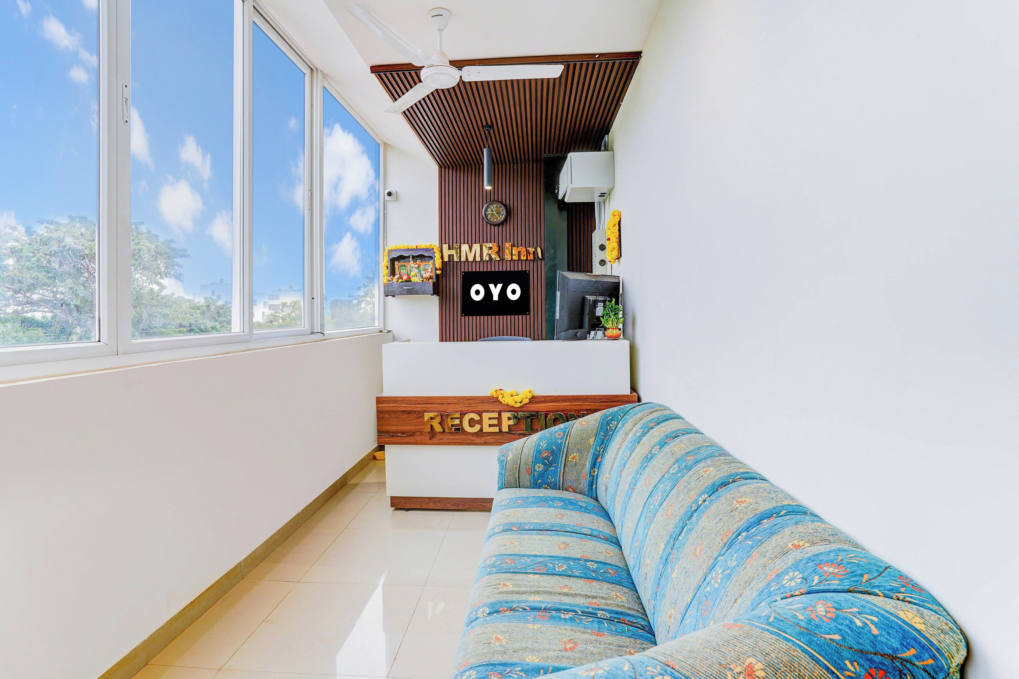 Una sala de estar moderna con un sofá, un mostrador de recepción y vistas amplias a través de grandes ventanales.