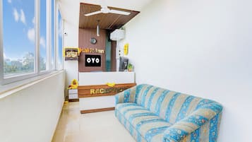 Un área de recepción con un sofá, un reloj y un cartel que dice 'OYO'.