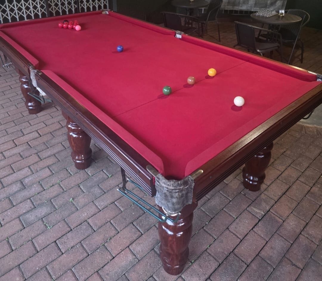 Una mesa de billar con bolas y estructura de madera.