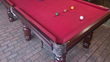 A pool table with balls and a wooden frame.