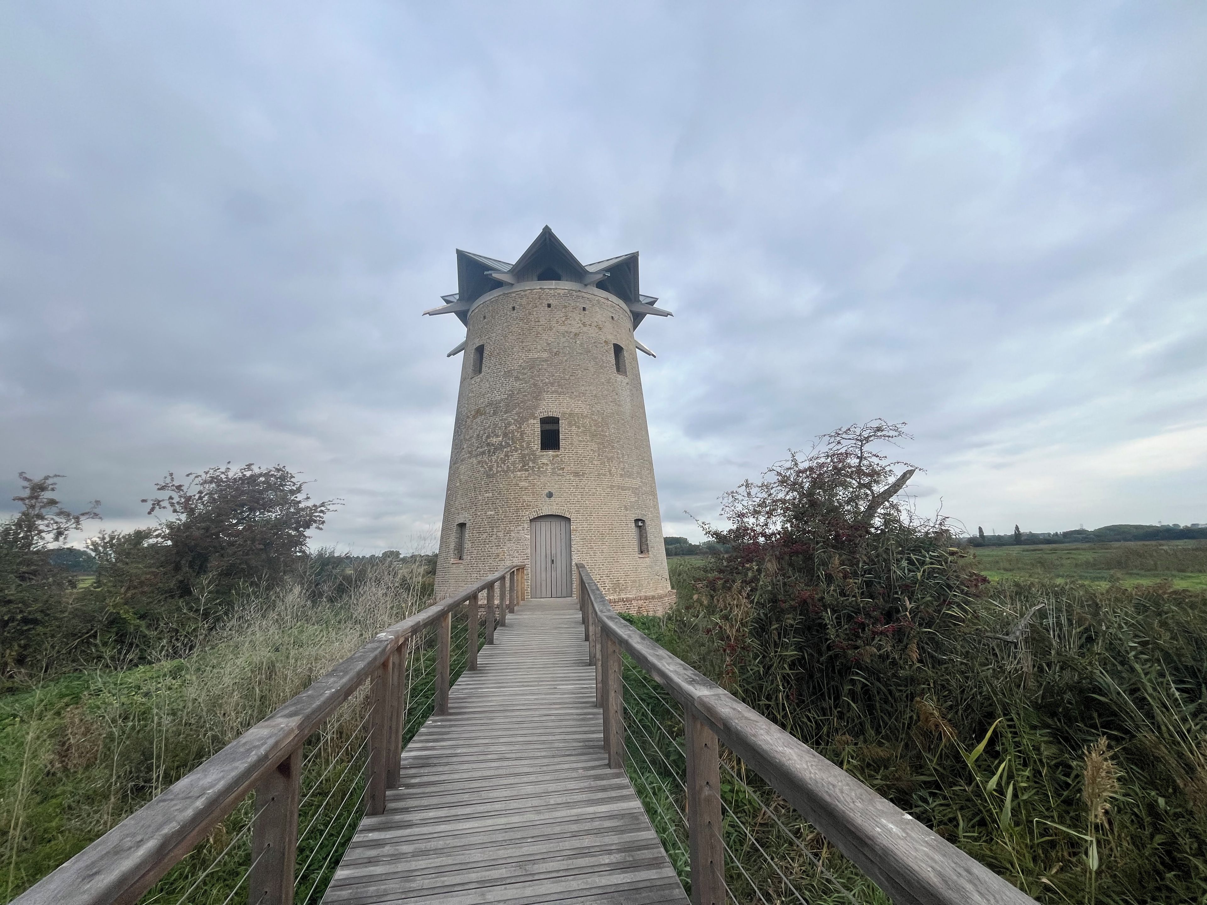 Ein Turm mit einem hölzernen Steg, der zum Eingang führt.