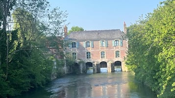 Een historisch gebouw met meerdere bogen en een rivier ervoor.