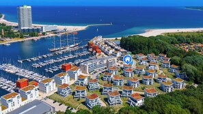 A coastal residential area with modern buildings, a marina, and a beach. - Dune Villa 18, Penthouse 10 (Lübeck-Travemünde)